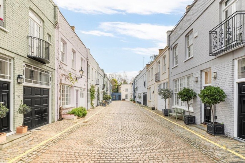 A cobbled mews in South Kensington, painted houses on each side