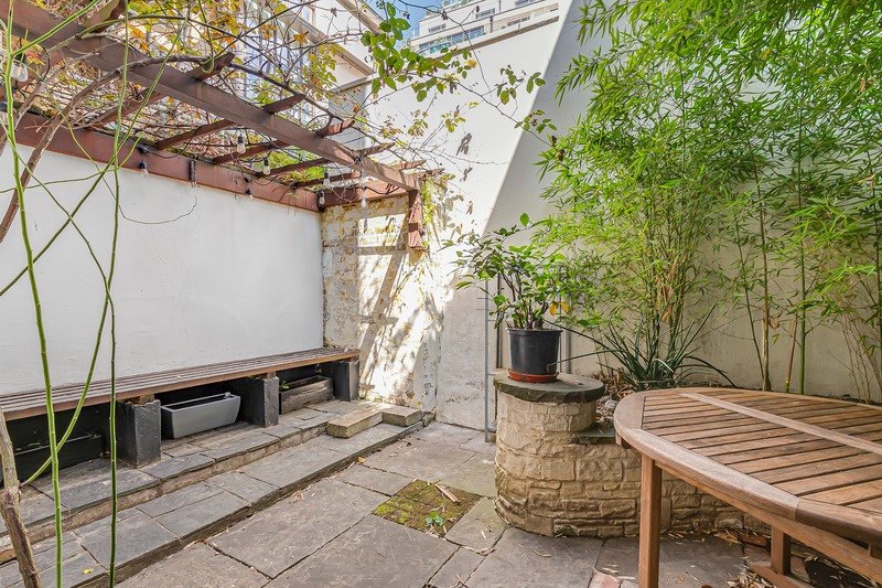 A walled garden with a wooden table